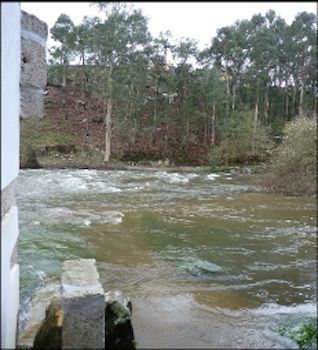 ponte submersa por rio com caudal cheio e bastante corrente
