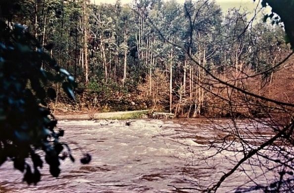 ponte submersa por rio com caudal cheio e bastante corrente