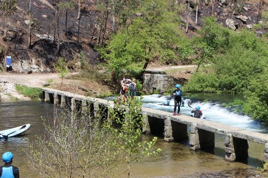 pessoas em cima de ponte de predra sobre o rio
