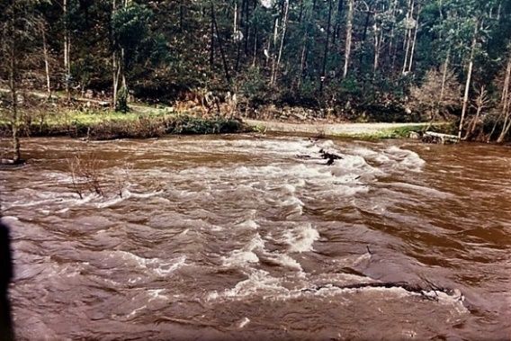 ponte submersa por rio com caudal cheio e bastante corrente